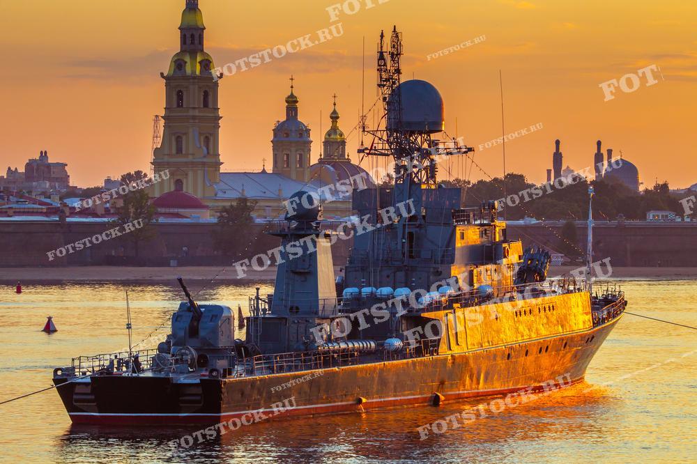 На фотографии изображен военный корабль на фоне Петропавловской крепости в Санкт-Петербурге на закате. 
Фото может использоваться для туристических буклетов, открыток и рекламных материалов.
